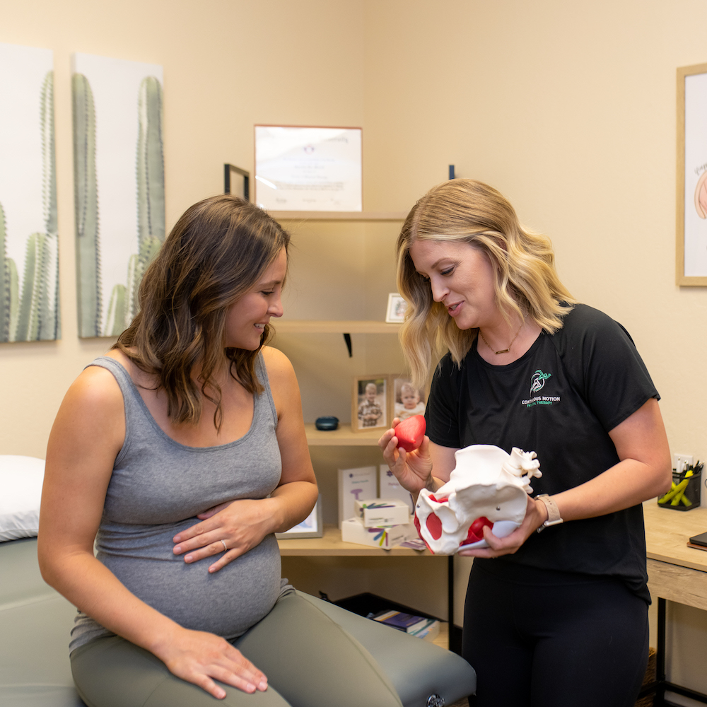 Two women in a doctor's office talking to each other.
