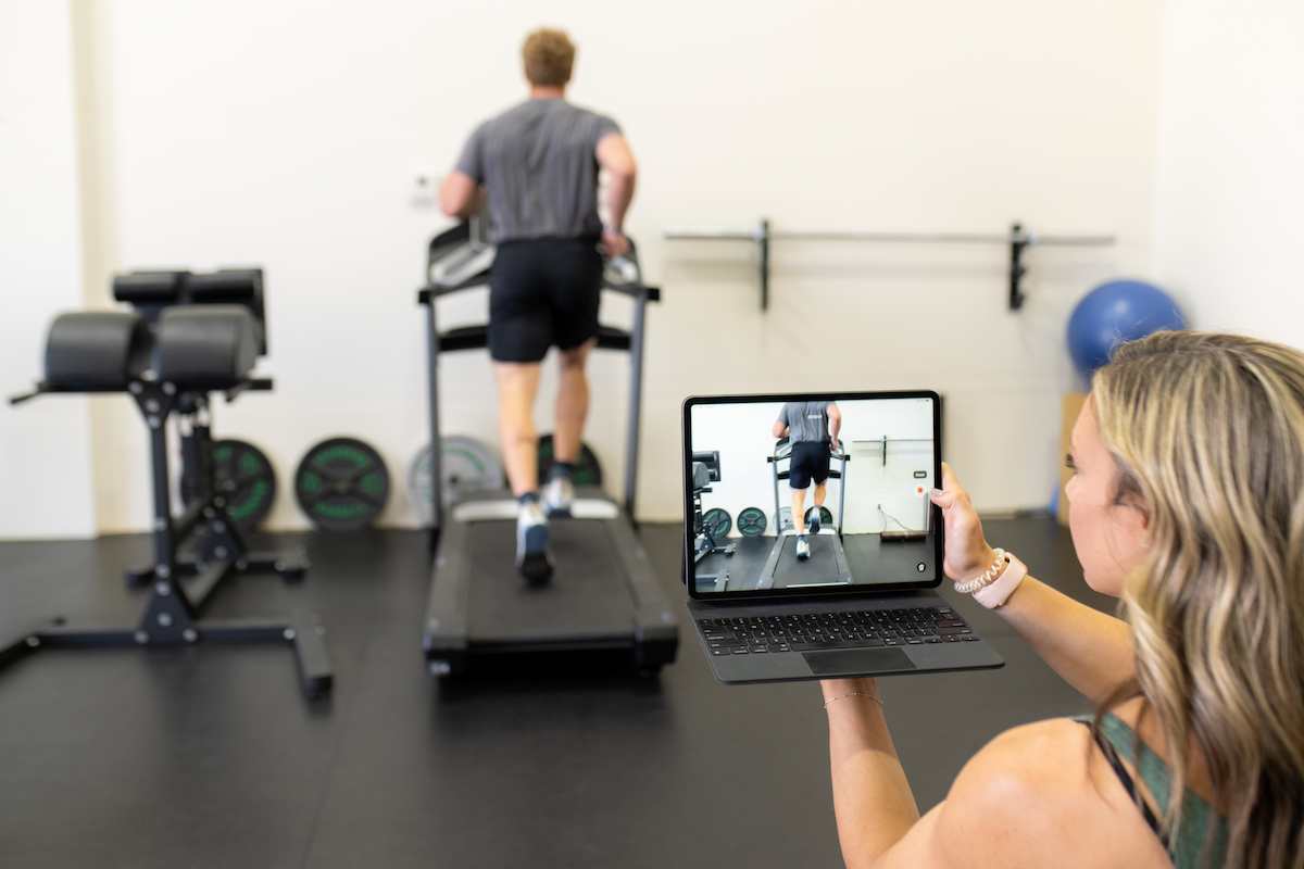A woman is taking a picture of herself on a treadmill.