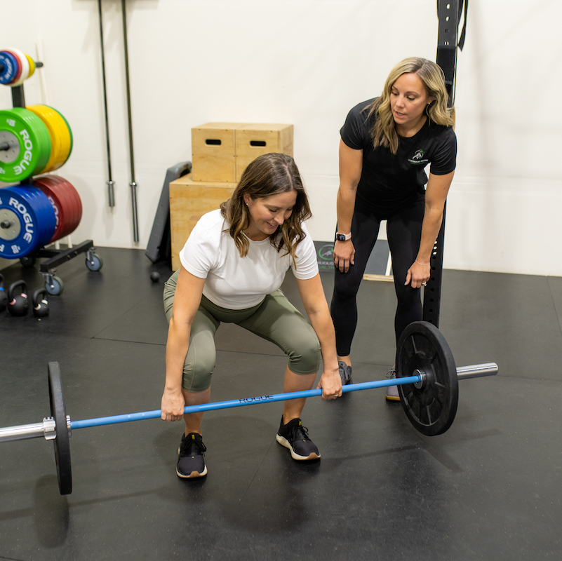 A woman squatting with a barbell.