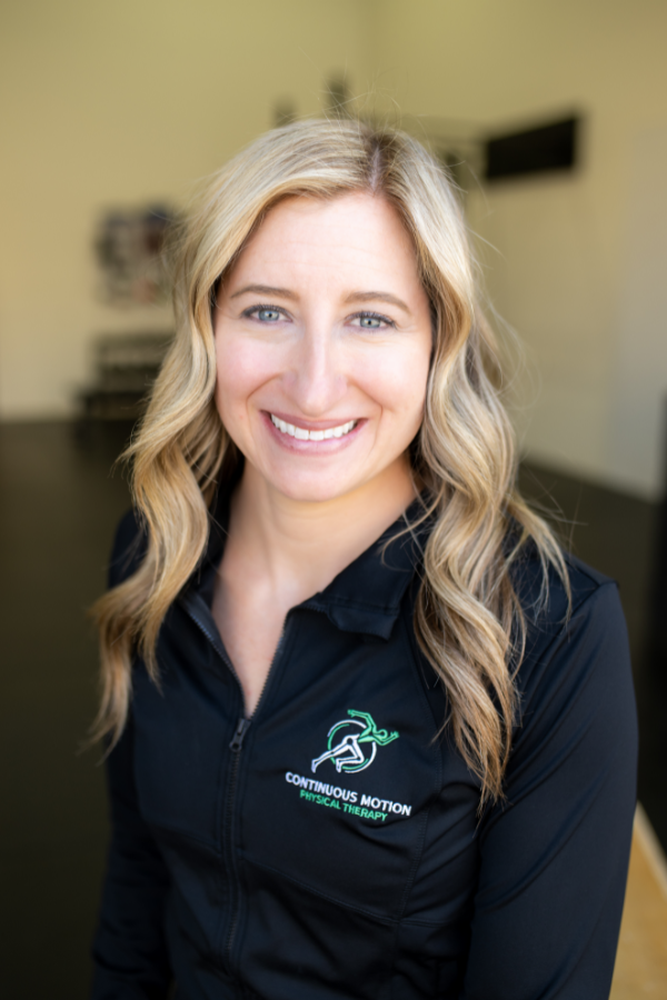 A smiling woman in a black jacket.