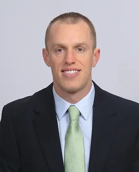 A man in a suit and tie smiling.